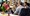 Five work colleagues sitting in a casual group amongst their workstations having a friendly chat
