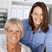 Two work colleagues in an office environment looking at us and smiling