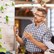 A man looking at, and standing in front of a white board talking about its content