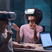 Two women sitting at a table wearing VR headsets