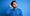 Thinking man scratching his head and wearing a blue top on a blue background